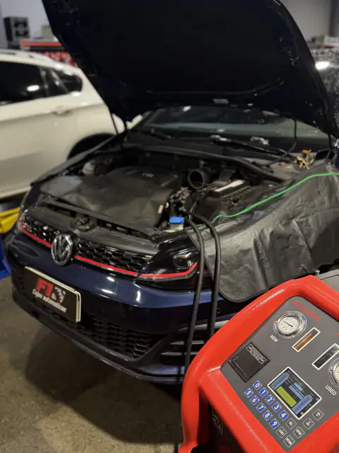 Volkswagen azul con capó abierto y las mangueras del equipo de diálisis conectadas al vano motor