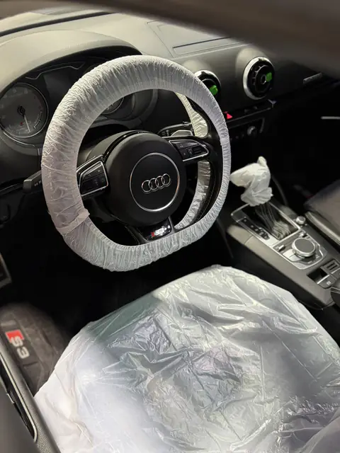 Interior de Audi S3 con fundas plásticas en volante, palanca de cambios y asiento