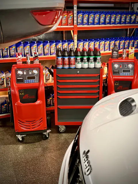 Dos equipos de diálisis y cajonera Würth con botellas de ATF Liqui Moly, frente a estanterías de aceite