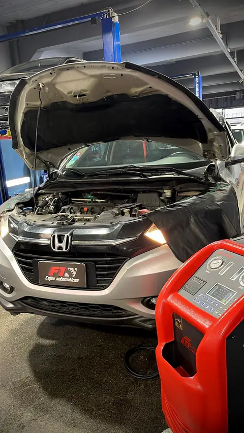 Honda plateada con capó abierto, cubreguardabarros y chapa F1, junto al equipo de diálisis