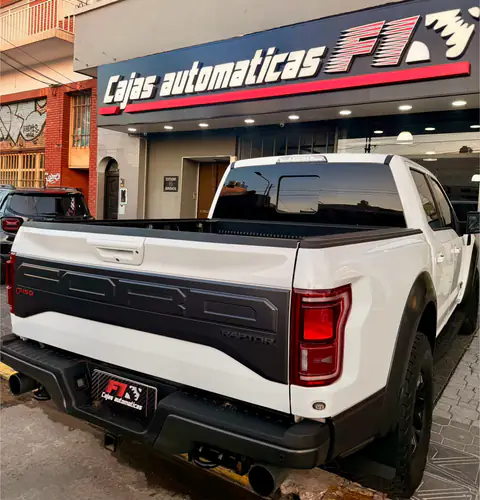 Ford F-150 Raptor blanca vista desde atrás frente al local de Cajas Automáticas F1