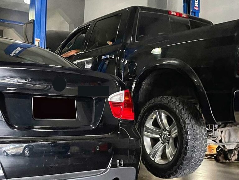BMW y camioneta negra dentro del taller F1