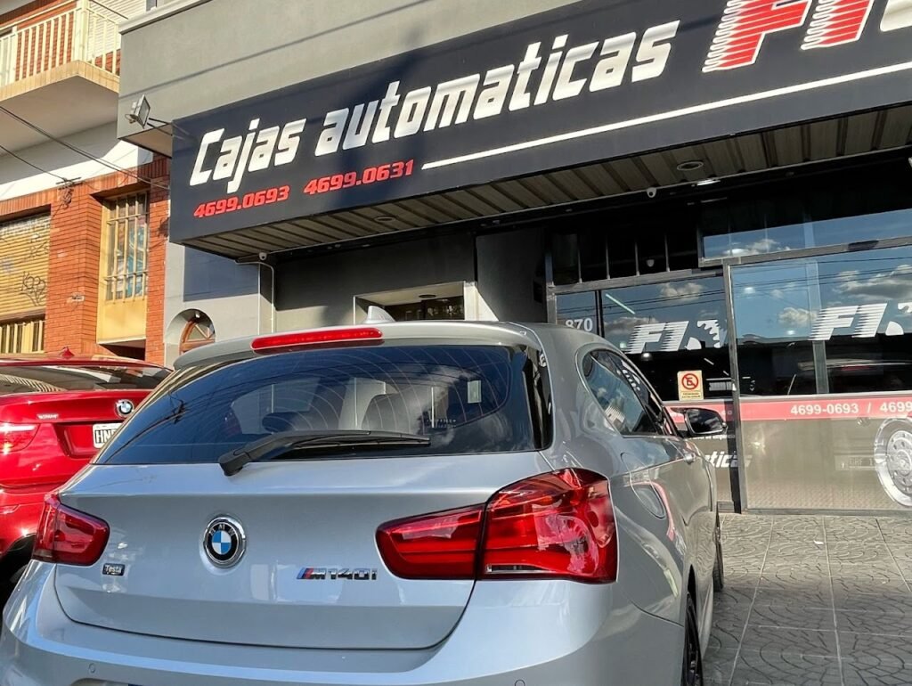 BMW gris estacionado frente al cartel de Cajas Automáticas F1