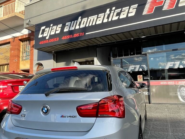 BMW gris estacionado frente al cartel de Cajas Automáticas F1