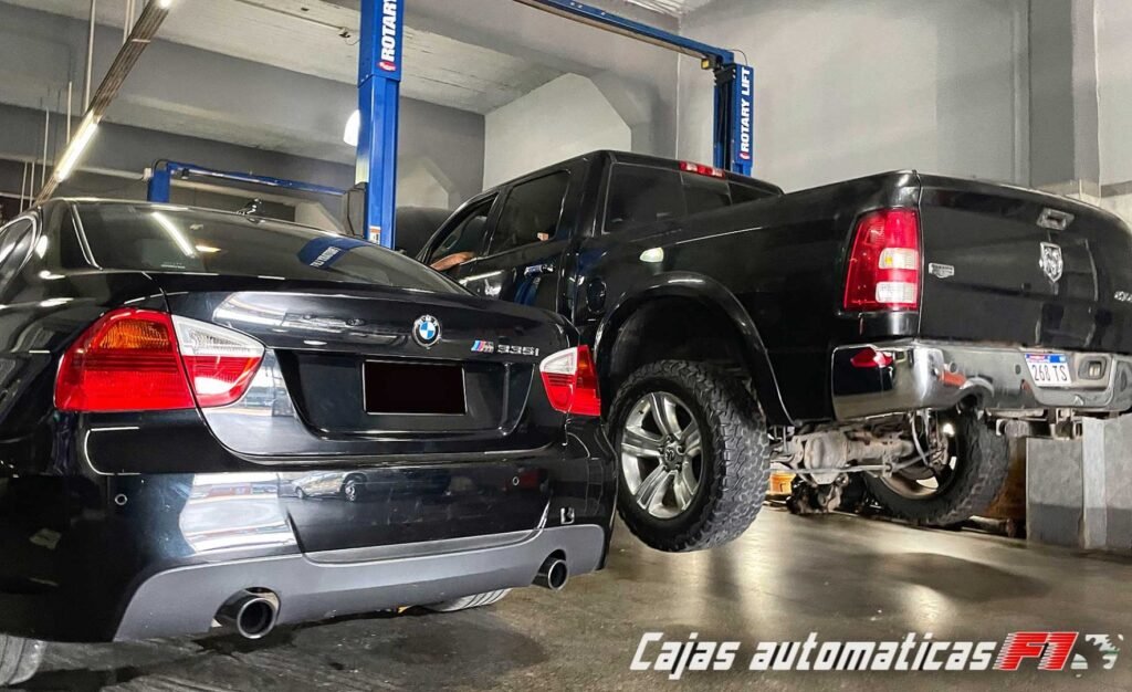 Área de trabajo del taller con un BMW y una camioneta en los elevadores