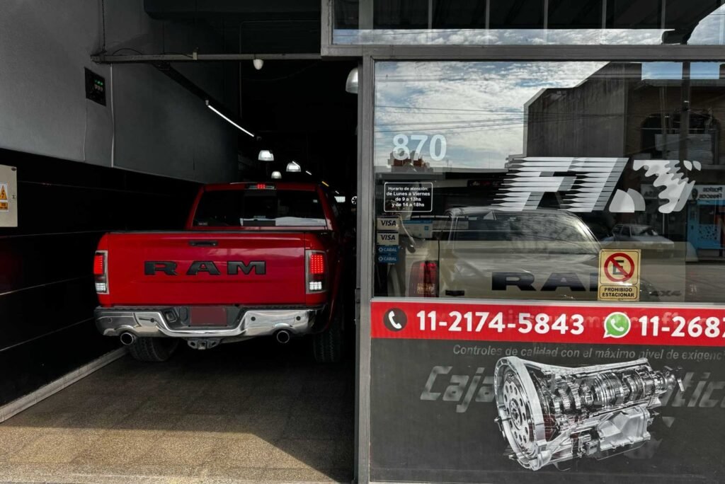 Portón de ingreso del taller F1, en el número 870, con una camioneta RAM roja