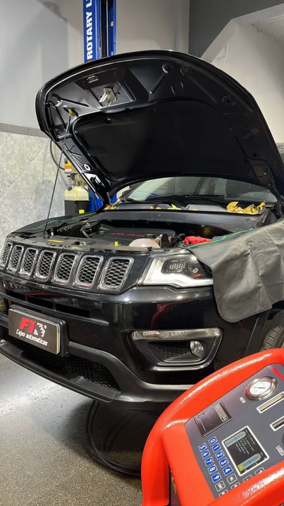 Jeep Compass negro con el capó abierto en el taller F1