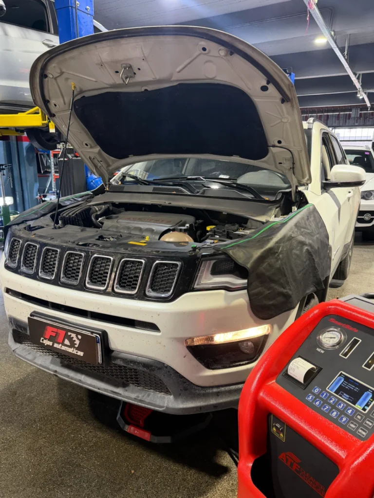Jeep Compass blanco con el capó abierto, conectado a un equipo para el servicio de la transmisión