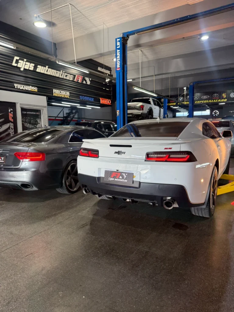 Chevrolet Camaro blanco sobre un elevador en el taller F1